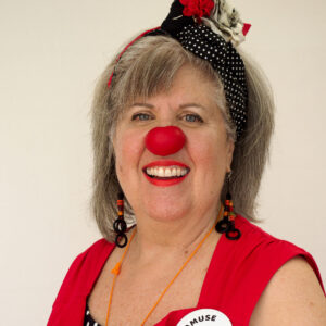 Femme déguisée en clown avec nez rouge.
