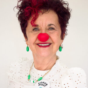 Femme souriante avec nez rouge de clown.