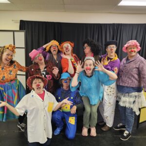 Groupe de clowns souriants en costumes colorés.