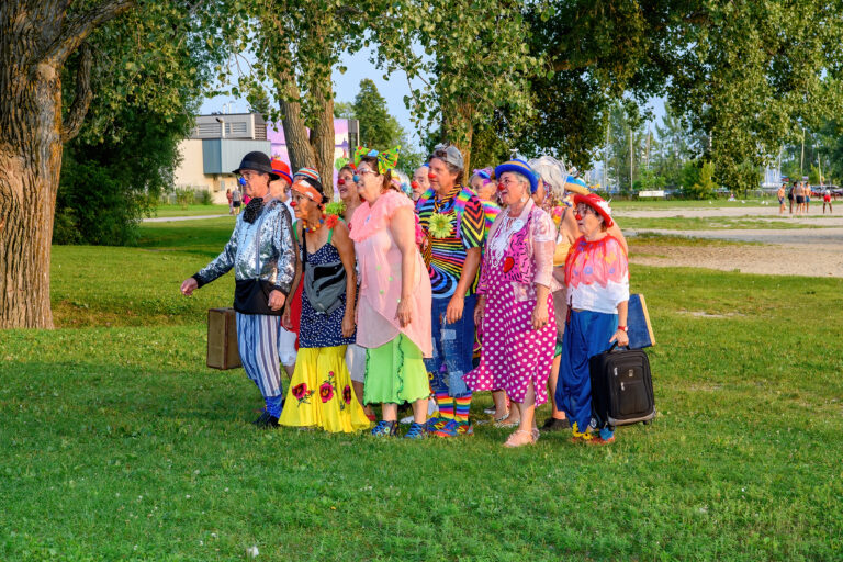 Groupe de clowns colorés dans un parc.