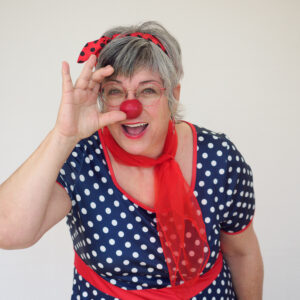 Clown joyeux avec nez rouge et tenue à pois.